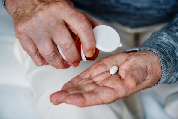 elderly person drinking a pill